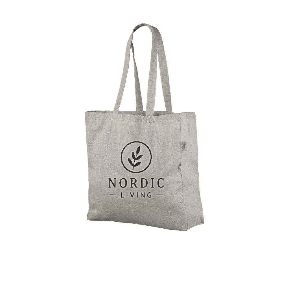 Voorbeeld van logobedrukking in één kleur op de lichtgrijze gerecyclede draagtas van 140 g/m², waarop het voorbeeldontwerp op de tas te zien is.