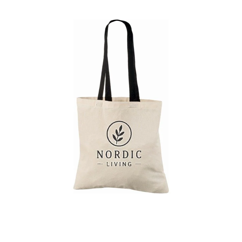Exemplo de impressão de logótipo a uma cor no saco tote de algodão natural de 140 g/m² com alças pretas, mostrando o design de exemplo no saco.